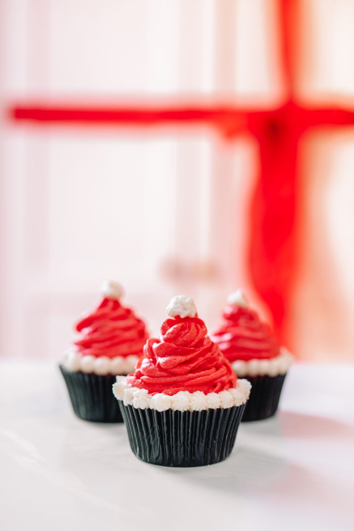 A close up of three santa hat cupcakes