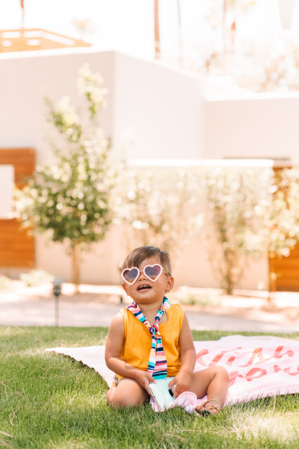 A little boy that is sitting in the grass