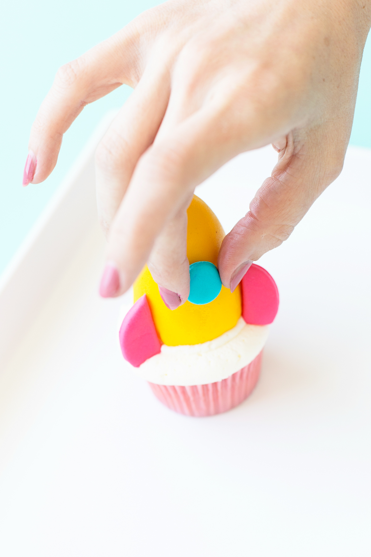 Putting rocket ship on cupcake