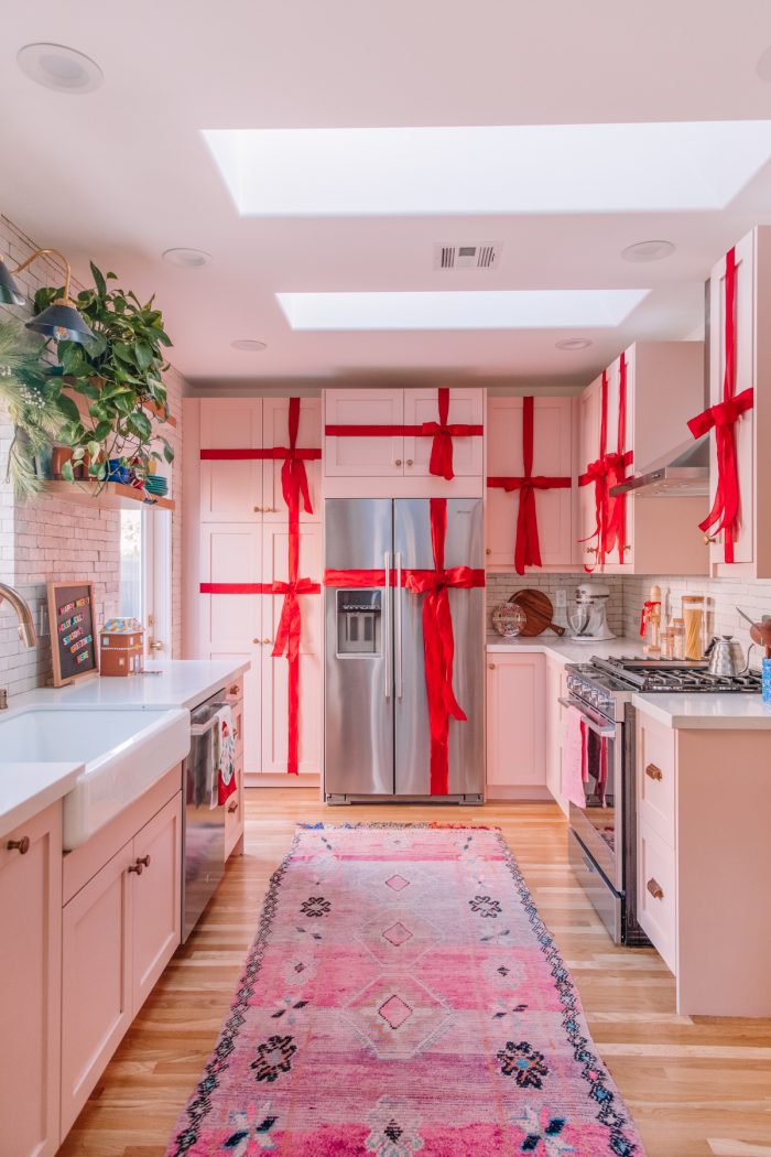 Kitchen with cabinets wrapped in red ribbon to look like presents. 