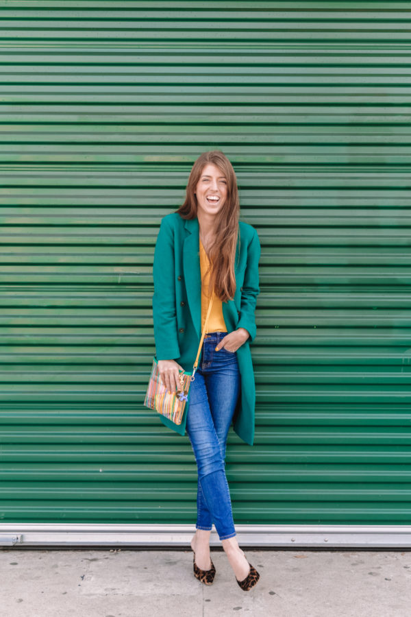 A woman standing in front of a green wall