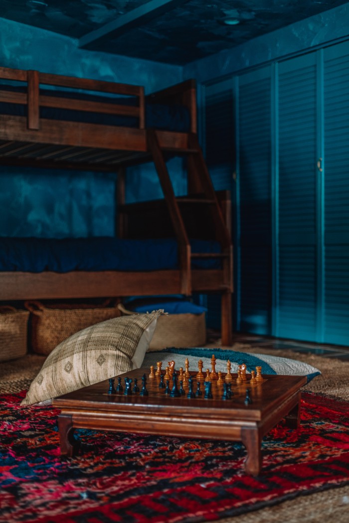 chess table on red rug in teal room