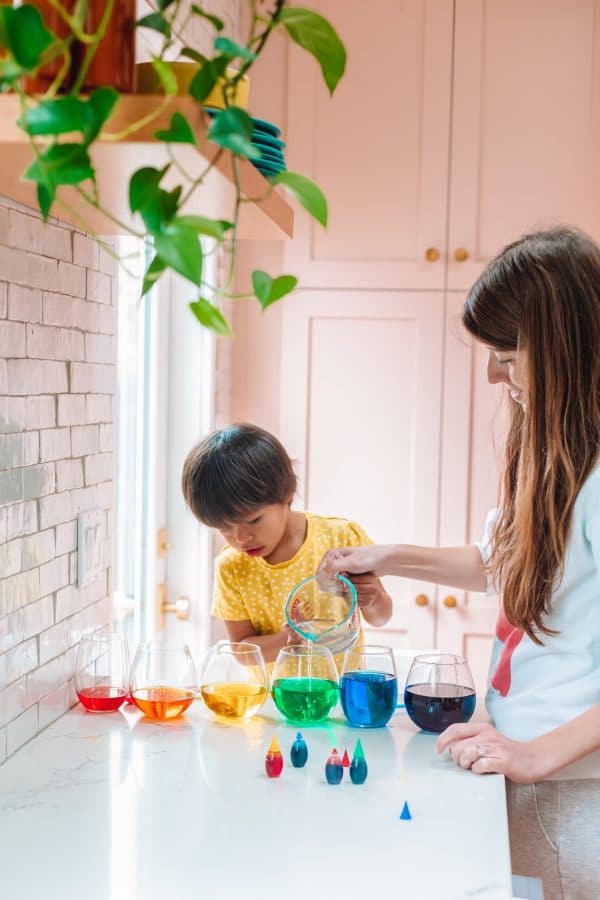 A woman standing in a kitchen with her son