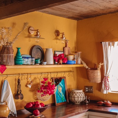 yellow kitchen with wood ceiling and shelf with colorful decor and dishes